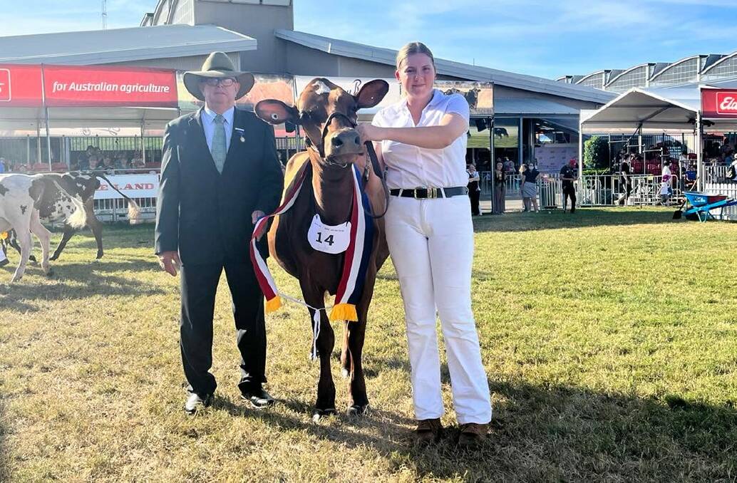 Judge Kevin Smith, Hillcrest, Borallon via Ipswich, Qld, with the junior champion Ayrshire female Mayfield Farms Tuxedo Showcase shown by Paul and Vicki Timbs, Mayfield Farms, Jaspers Brush, and led by Georgia Hearn, Nowra. 