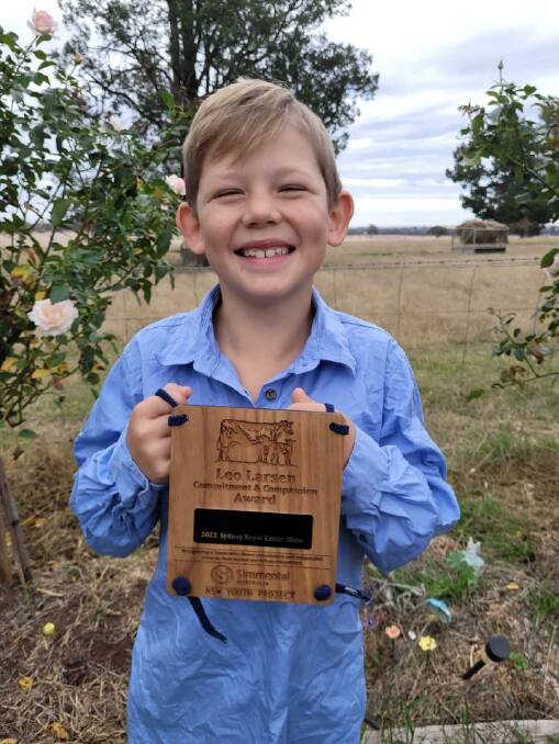 Eight-year-old George Baldry with the Leo Larsen Commitment and Compassion Award plaque.