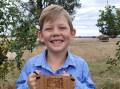 Eight-year-old George Baldry with the Leo Larsen Commitment and Compassion Award plaque.