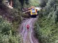 An emergency worker stands on the railway tracks before a derailed passenger train in Germany. Photo: EPA PHOTO