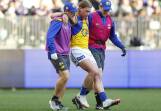Harley Reid is helped off the ground after suffering an ankle injury in the loss to the Dockers.
 Photo: James Worsfold/AAP PHOTOS