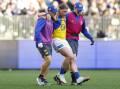Harley Reid is helped off the ground after suffering an ankle injury in the loss to the Dockers.
 Photo: James Worsfold/AAP PHOTOS