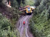 An emergency worker stands on the tracks before a derailed passenger train in southern Germany. Photo: EPA PHOTO
