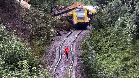 An emergency worker stands on the tracks before a derailed passenger train in southern Germany. Photo: EPA PHOTO