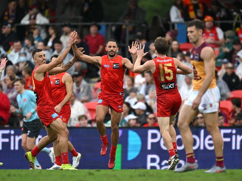 Ben Long (centre) rediscovered top form, finishing with four goals in the mauling of the Lions. Photo: Dave Hunt/AAP PHOTOS