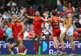 Ben Long (centre) rediscovered top form, finishing with four goals in the mauling of the Lions. Photo: Dave Hunt/AAP PHOTOS