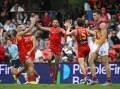 Ben Long (centre) rediscovered top form, finishing with four goals in the mauling of the Lions. Photo: Dave Hunt/AAP PHOTOS