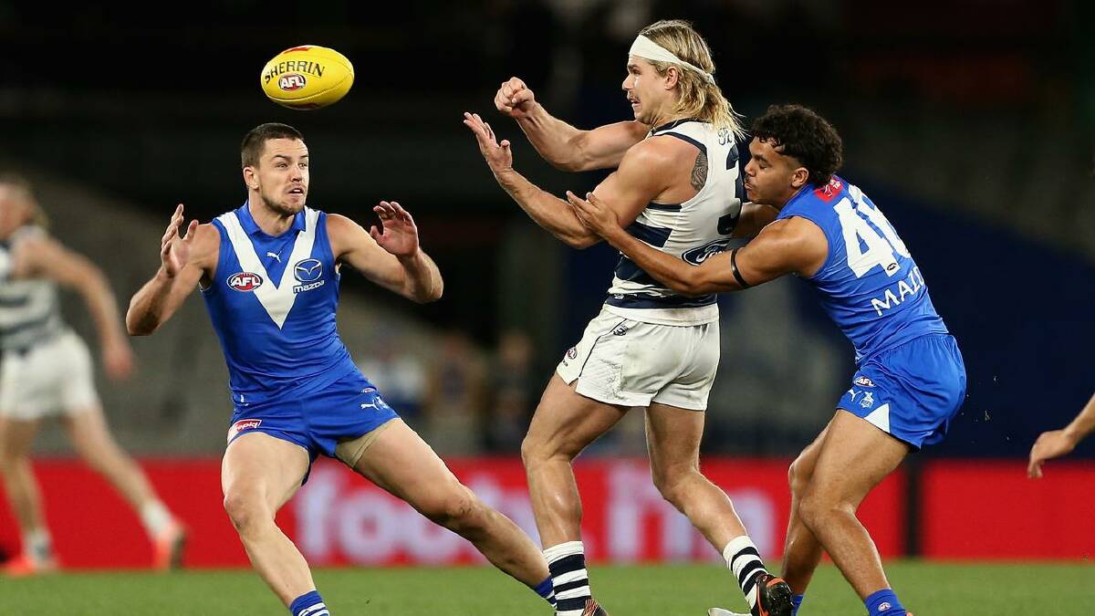 The Cats' Bailey Smith fires out a handball in the crushing win over North Melbourne.  (Rob Prezioso/AAP PHOTOS)