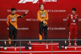 Oscar Piastri  is flanked on the rostrum by Lando Norris (left)  and Ferrari's Charles Leclerc.  Photo: AP PHOTO