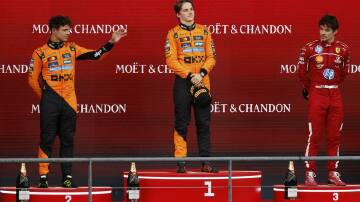 Oscar Piastri  is flanked by McLaren team-mate Lando Norris and Ferrari's Charles Leclerc.  Photo: AP PHOTO