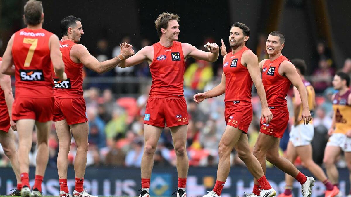 Skipper Noah Anderson (centre) led by example for the Suns, finishing with 33 disposals and a goal.  (Dave Hunt/AAP PHOTOS)