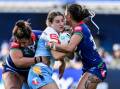 Titans try-scorer Lily Patston found herself surrounded in her side's win over the Warriors. Photo: Andrew Cornaga/AAP PHOTOS