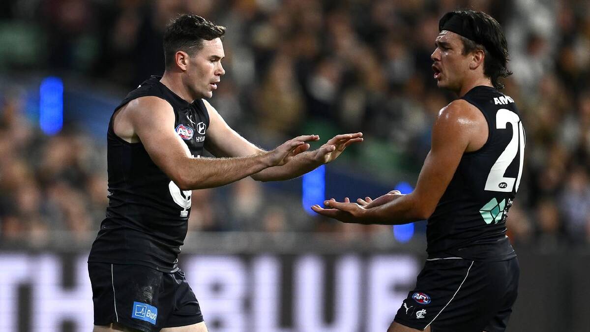 Hollands (r) and Mitch McGovern celebrate a goal in the infamous April 16 match against the Magpies. (Joel Carrett/AAP PHOTOS)